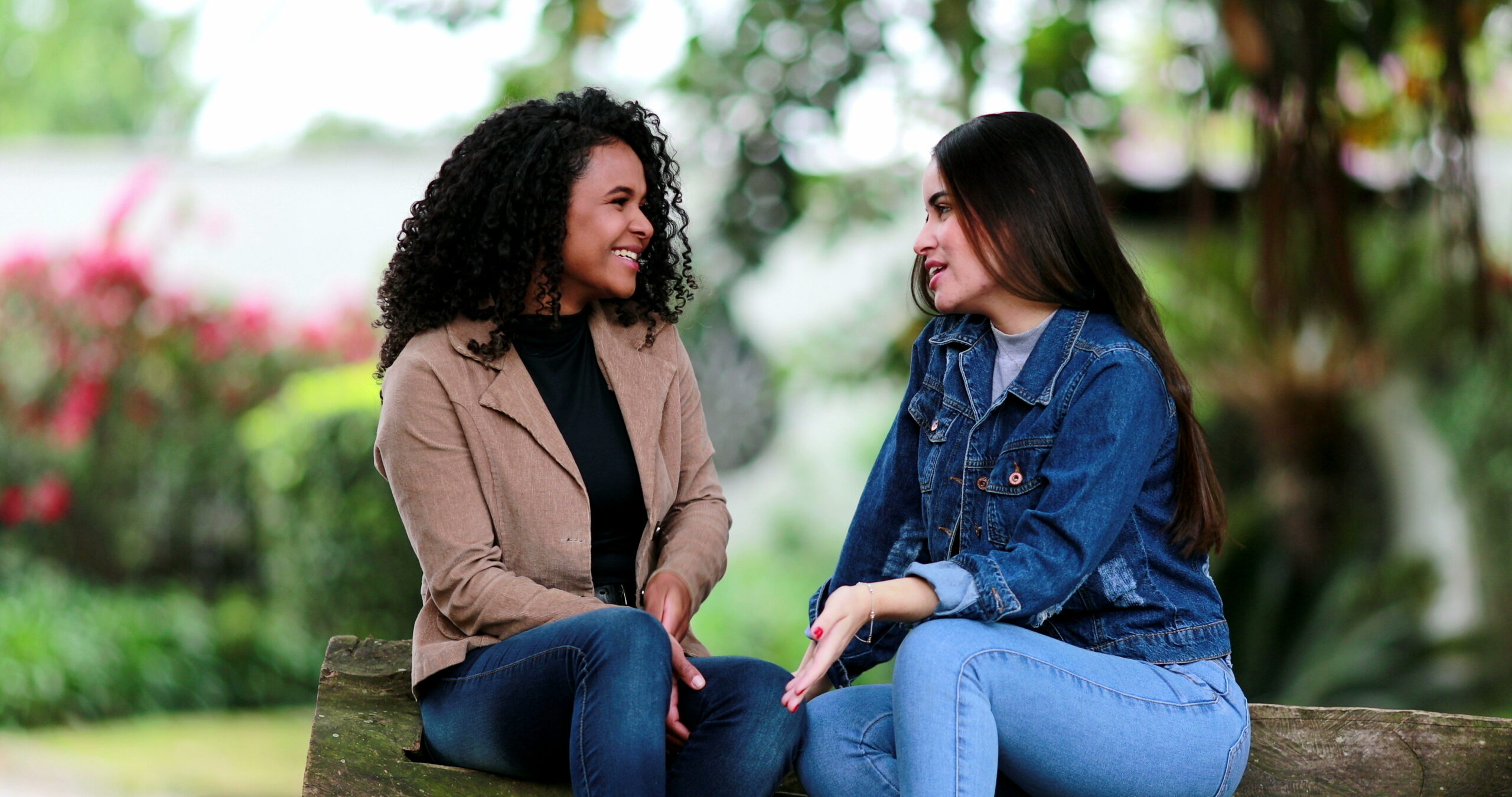 Two diverse girls talking outside together